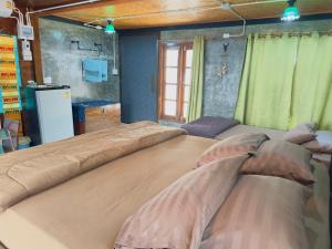 two large beds in a room with green curtains at Homestay Baan Ik-ka-lik in Nan