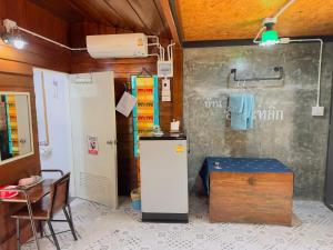 a room with a refrigerator and a table and a chair at Homestay Baan Ik-ka-lik in Nan +27 photos
