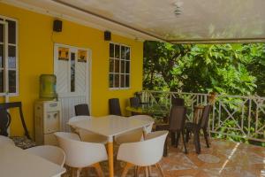 a dining room with a table and chairs on a patio at POSADA NATIVA DERMA´S INN in San Andrés