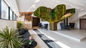 eine Lobby mit einem großen grünen Herz, das von der Decke hängt in der Unterkunft Magia Hotel - Spa & Wellness in Avcılar