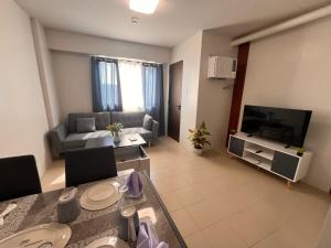 a living room with a couch and a television at Plumera Mactan Square in Mactan Island