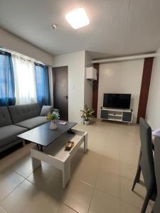 a living room with a couch and a table at Plumera Mactan Square in Mactan Island