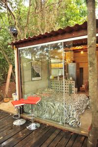 a screened in porch with two stools and a table at Casinha Natureza in Brasília