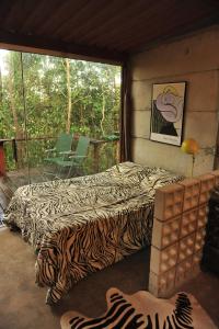 two beds in a room with a balcony at Casinha Natureza in Brasília