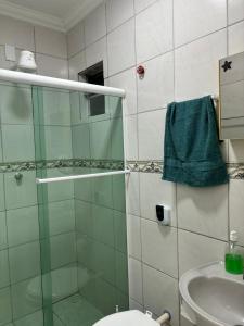 a bathroom with a shower and a toilet and a sink at Suíte sossego in Rio das Ostras