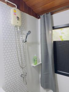 a shower with a shower curtain in a bathroom at Homestay Baan Ik-ka-lik in Nan