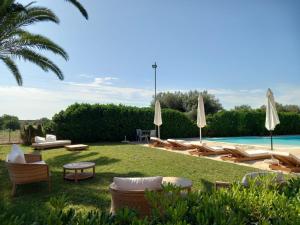a group of chairs and umbrellas next to a pool at Hotel Lady Lusya in Syracuse