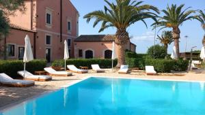 a pool with chaise lounge chairs and palm trees at Hotel Lady Lusya in Syracuse