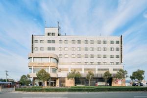 a white building with a tower on top of it at COZY HOTEL NUKUI shimanami in Imabari