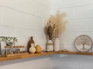 a shelf with vases and other items on it at Family & Couples Beachside Stay Ocean Glimpses 7 day Xmas 2026 available in Brooms Head