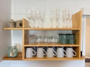 a shelf with wine glasses and other glass items at Family & Couples Beachside Stay Ocean Glimpses 7 day Xmas 2026 available in Brooms Head