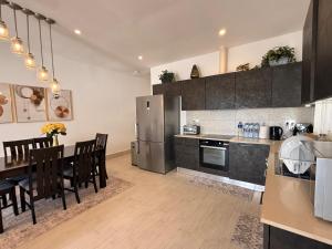 a kitchen with a dining table and a refrigerator at Luxury & Comfort, with Pool and Ocean Views in Bijilo