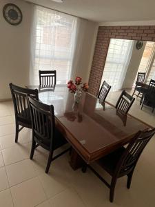 a dining room table with chairs and a vase of flowers at Rey 179 in Morelia +13 photos