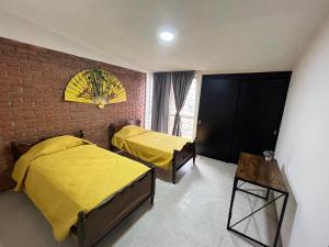 a bedroom with two beds and a brick wall at Rey 179 in Morelia