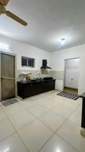 a large kitchen with a large white tile floor at Simba Stay's 2BHK 1 in Chikmagalūr
