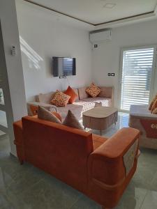 a living room with a couch and a tv at Djerba Haven Family in Houmt Souk