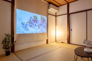 a room with a projection screen on the wall at Tsubaki in Otsu