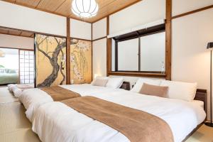 a large bed in a room with windows at Tsubaki in Otsu