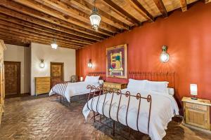 due letti in una stanza con pareti arancioni di Mirador del Frayle a San Miguel de Allende Altre 69 foto