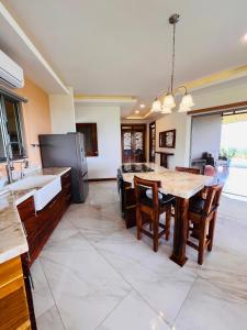 a kitchen with wooden tables and a kitchen with a refrigerator at Loma Linda in Arenal