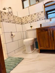 a bathroom with a toilet and a sink and a mirror at Loma Linda in Arenal +17 photos