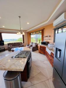 a kitchen and living room with a stove and refrigerator at Loma Linda in Arenal