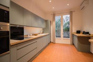 a kitchen with gray cabinets and an orange tile floor at Maison Vauban in Marseille