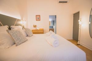 a bedroom with a large white bed with white pillows at Maison Vauban in Marseille