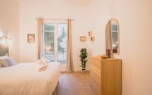 a bedroom with a bed and a mirror and a dresser at Maison Vauban in Marseille