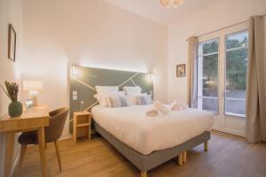 a bedroom with a bed and a desk and a window at Maison Vauban in Marseille +11 photos