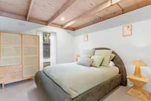 a bedroom with a bed and a wooden ceiling at Villa Syrene Pool and Spa Retreat in Rye +37 photos