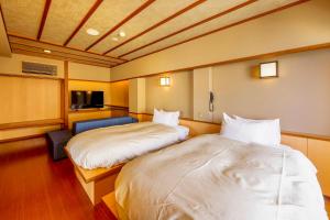 a room with two beds and a chair in it at Senoumi in Higashiizu