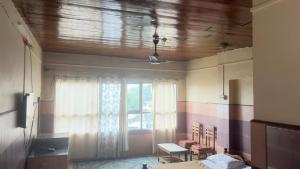 a room with a window and a table and chairs at Vega tourist lodge in Madikeri