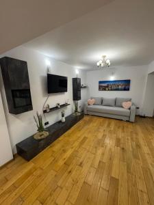 ein Wohnzimmer mit Sofa und Fernseher in der Unterkunft Apcentral in Fălticeni