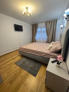ein Schlafzimmer mit einem Bett und einem Fernseher in der Unterkunft Apcentral in Fălticeni