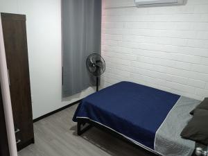 a bedroom with a bed with a blue blanket at Depa Risalud! in Santa Cruz Huatulco