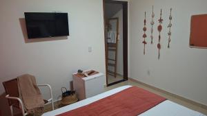 a bedroom with a bed and a tv and a mirror at Costamar Galinhos in Galinhos