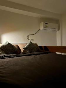a bedroom with a bed with a air conditioner on the wall at Baler Modern Studio Loft Haven in Baler