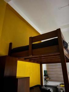 a bunk bed in a room with a yellow wall at Baler Modern Studio Loft Haven in Baler