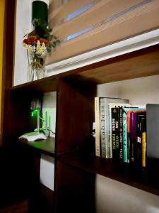 a book shelf with books and a vase of flowers at Baler Modern Studio Loft Haven in Baler