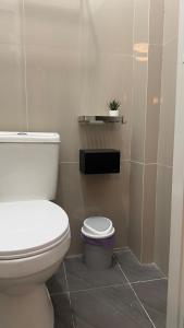 a bathroom with a white toilet and a plant at Baler Modern Studio Loft Haven in Baler +10 photos