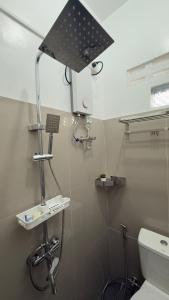 a bathroom with a toilet and a light on the wall at Baler Modern Studio Loft Haven in Baler