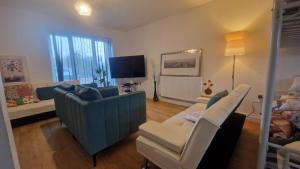a living room with a couch and chairs and a tv at Amani Sanctuary 2 Bedroom House in Sherburn Hill