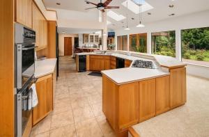 a large kitchen with wooden cabinets and a ceiling fan at Star Lake Shores in Kent