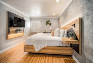 a bedroom with a large bed and a tv at The Beverly House by AGA - Beverly Hills in Los Angeles