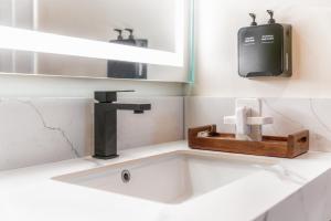 a bathroom sink with a faucet and a mirror at The Beverly House by AGA - Beverly Hills in Los Angeles