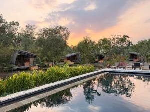a pool at a resort with a sunset in the background at Homestay in Nhơn Trạch