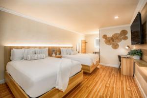a bedroom with two beds and a flat screen tv at The Beverly House by AGA - Beverly Hills in Los Angeles +7 photos