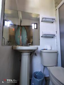 a bathroom with a sink and a toilet and a mirror at Hospedaje 'Los Ángeles ' in Huasca de Ocampo