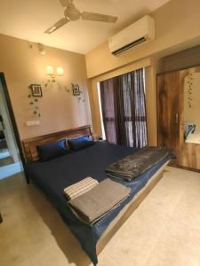 a bedroom with a bed with blue pillows and a window at Staycation Couple friendly House in Thane